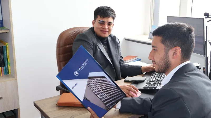 Edson Galvis y Elkin Trujillo revisando documentos en la oficina